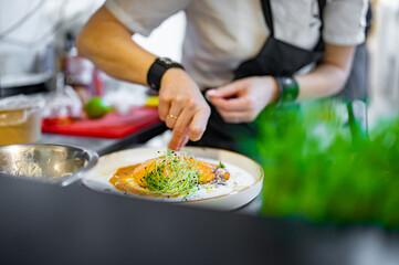 Chef cooking Roasted salmon steak with pumpkin cream on restaurant kitchen