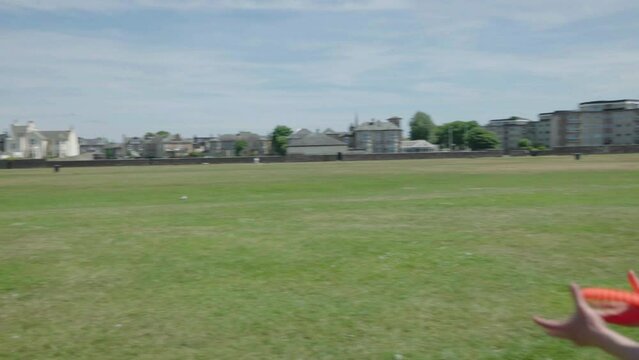 Two men throwing frisbee to each other outdoor in the sun, slow motion