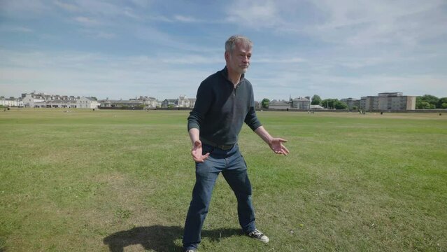Two men playing with an orange frisbee outside captured in slow motion