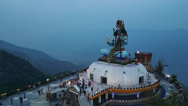 Drone pullback reveals blue haze mountains behind shiva statue pumdikot nepal