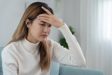 Headache, female having migraine pain, bad health, Asian woman feeling stress and headache, Office syndrome, sad tired touching forehead having migraine or depression, irritated girl, sadness grief