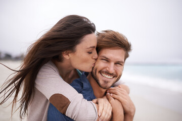 Woman kiss man, happiness and beach with holiday, travel and love with care and trust outdoor....