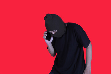 Thief wearing a hand mask while making a phone call