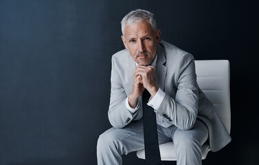 Serious portrait of senior lawyer on chair with confidence, mockup space and dark background in studio. Pride, professional career ceo and executive attorney, mature businessman or law firm boss.