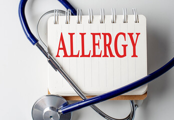 ALLERGY word on notebook with medical equipment on background