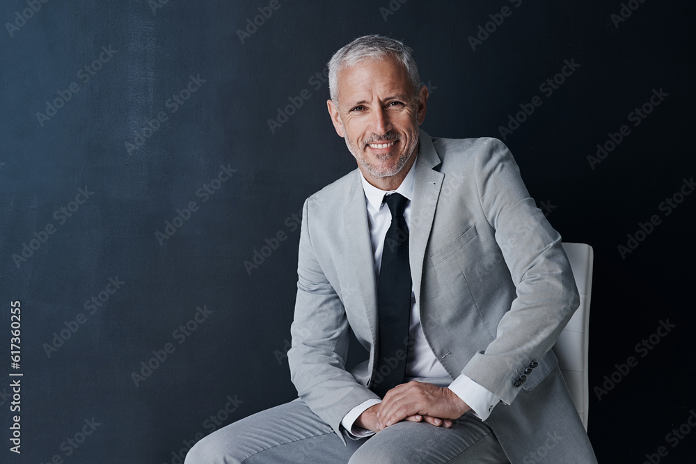 Poster Studio portrait, happy businessman and chair in mockup space with confident boss on dark background. Smile, pride and professional career for executive, mature startup business owner or startup ceo.