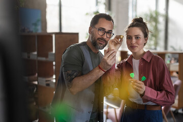 Happy colleagues having break at work, playing darts.