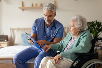 Caregiver doing regular check-up of senior woman in her home.