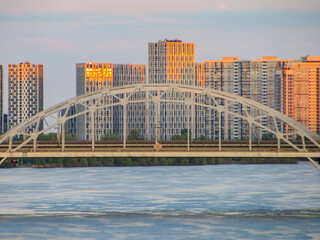 Arc Bridge Over the River with modern city building at Sunset With Copy Space