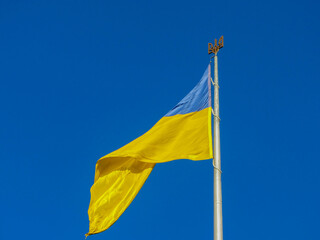 Ukraine flag large national symbol fluttering in blue sky. Large