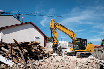 Retroescavadora a demolir uma casa velha para posteriormente se fazer uma nova construção no local