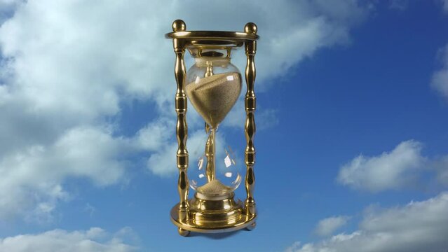 Time flies backwards into the past. Timelapse hourglass going backwards back in time and zooms towards the camera with a timelapse sky and clouds in the background,