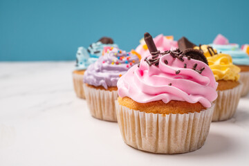 Delicious homemade cupcakes with Colorful cream and topping with candy and Chocolate Cookies. Homemade autumn holiday dessert