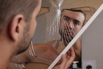 Man holding a broken mirror 
