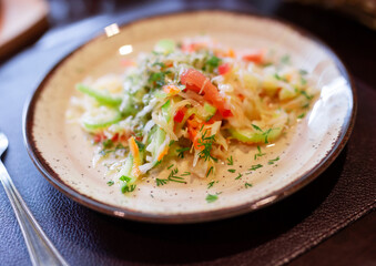 Fresh vegetable salad with tomatoes, cucumbers and celery on plate