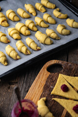 process of making traditional ukrainian baked goods - crescents with homemade rose jam.
