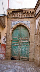 Green, wooden door with tile trim in the Medina in Essaouira, Morocco