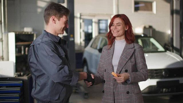 good car service, joyful female transport owner talking to male mechanic and getting good news about engine repair at technical site