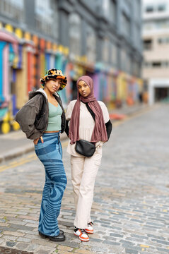 Portrait of young women standing on city street