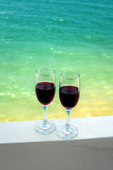 two glasses of wine on the background of the sea surface