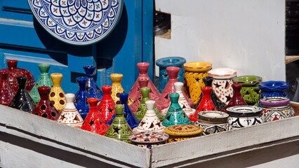 Tajines and other colorful ceramics on a table at a shop in the Medina in Essaouira, Morocco