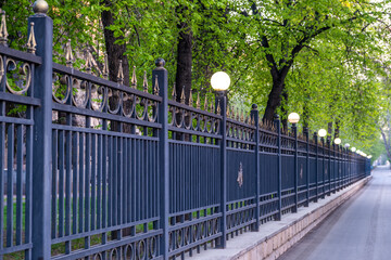 A long metal fence with sharp peaks in the city.