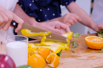Young woman using a knife to cut bell peppers.