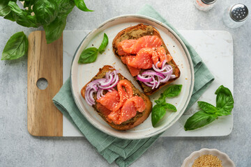 Sandwiches with salted salmon, avocado guacamole, red onions and basil. Smorrebrod. Set of danish open sandwiches. Healthy food, breakfast. Clean eating, dieting, vegan food concept. Top view.