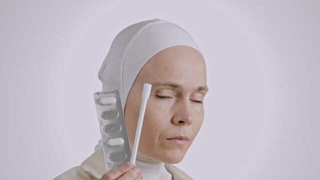 Serious muslim female with vaginal pills and suppository applicator