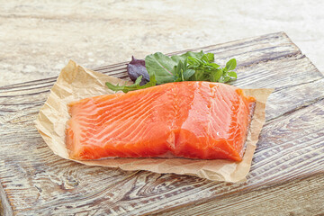 Raw salmon fillet over board