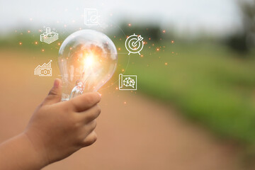 hand holding a bright light bulb. Concept of Ideas for presenting new ideas Great inspiration and innovation new beginning.Green background