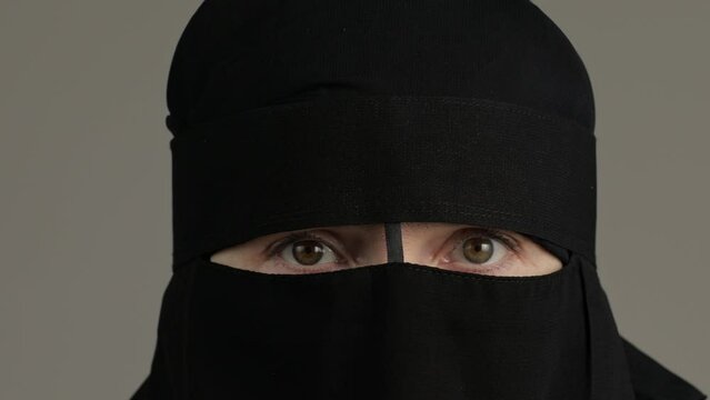 Scared muslim woman in niqab opens hers face