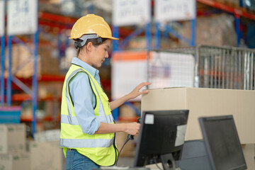 A female manager is checking inventory inside a warehouse.