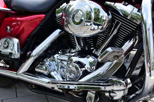 powerful large motorcycle engine block closeup view. beautiful shiny chrome finish. V engine. stainless exhaust pipes. red paint finish. engineering and mechanical design concept. recreation, outdoors