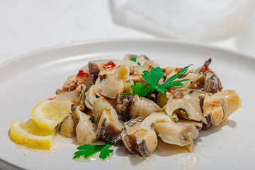 Rapana clam meat with oil, spices and greens. Healthy seafood is rich in omega. Marine decor
