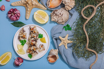 Pickled rapan meat with oil, spices and greens. Healthy seafood rich of omega