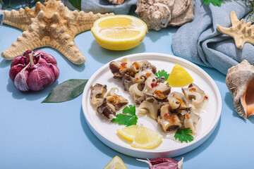 Pickled rapan meat with oil, spices and greens. Healthy seafood rich of omega