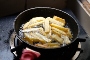 French fries in a black fryer. deep fryer. fried in hot palm oil. kentang goreng.