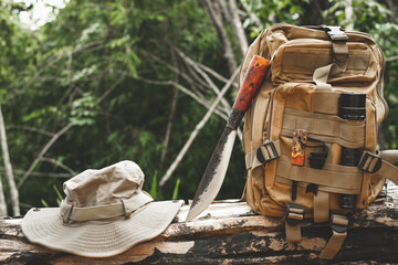 A knife backpack with equipment for survival in the forest on an old timber wooden