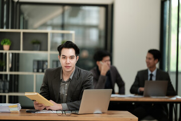 Fototapeta na wymiar Handsome cheerful asian man executive business man at the workspace office 
