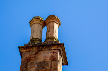 Double chimney stack rising into the bright blue sky