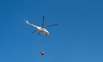 Fire Fighting and Rescue Helicopter put out a Fire. Fire helicopter with water bucket flies to forest fire.