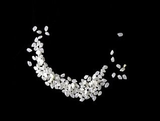 Heaps of uncooked Japanese short grain rice piled together isolated on black background.	
