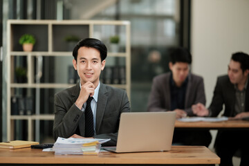 Handsome cheerful asian man executive business man at the workspace office 