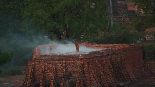 Smoke arising from the brick kiln used to prepare bricks in the villages of India. Smoke causes too much global warming and kiln releases too many harmful gases. Rural India background with copy space