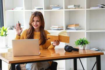 Happy latin girl college student watching distance online learning class, remote university webinar or having talk on laptop video call and use notebook to virtual meeting seminar at home or campus