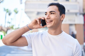 Young hispanic man smiling confident talking on the smartphone at coffee shop terrace