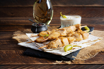 Chicken kebab with sour cream sauce. Chicken skewers on wooden background