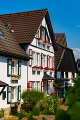 Fototapeta na wymiar Schwerte is a picturesque village in Ruhr Basin Germany near Dortmund. Old town with historical truss houses and half timbering is a tourist attraction on a sunny day. Colorful facades and flowers.