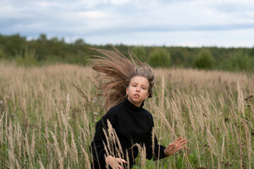 Naklejka na ściany i meble young girl posing in a field in a sweater